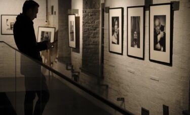 Osoba stojąca przy fotografiach z wystawy