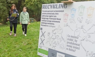 Dzieci przy tabliczce o recyklingu