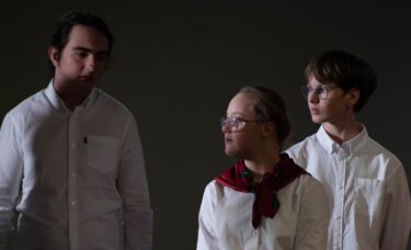 Dziewczynka na tle chłopaków. Tło przyciemnione. Zdjęcie artystyczne