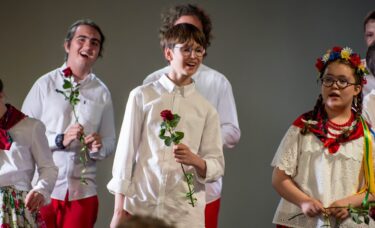 Grupa dzieci z kwiatami śpiewa na bis